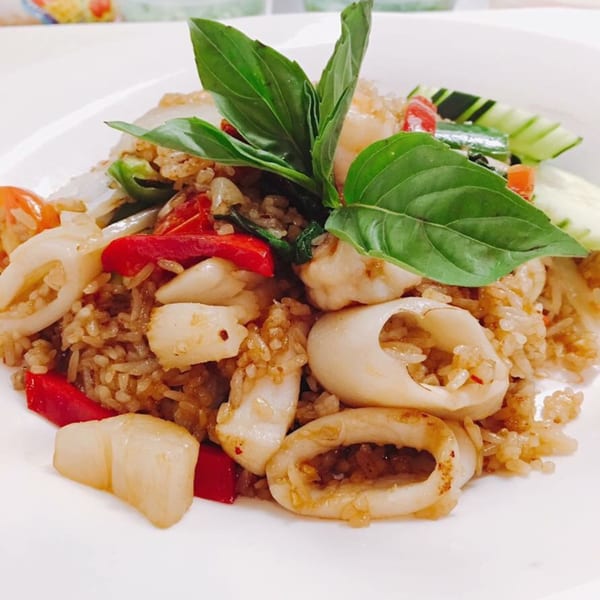 Sala Thai's fried rice with squid, red peppers, and basil on a white plate.