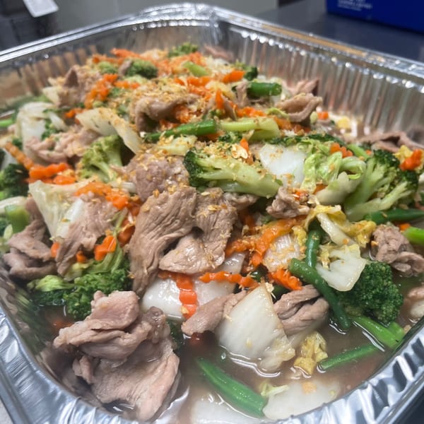 Sala Thai's Pad See Ew with wide noodles, pork, broccoli, carrots, and cabbage in a foil tray.