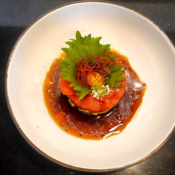 Thai tuna tartare with avocado, topped with a quail egg, shiso leaf, and chili threads.