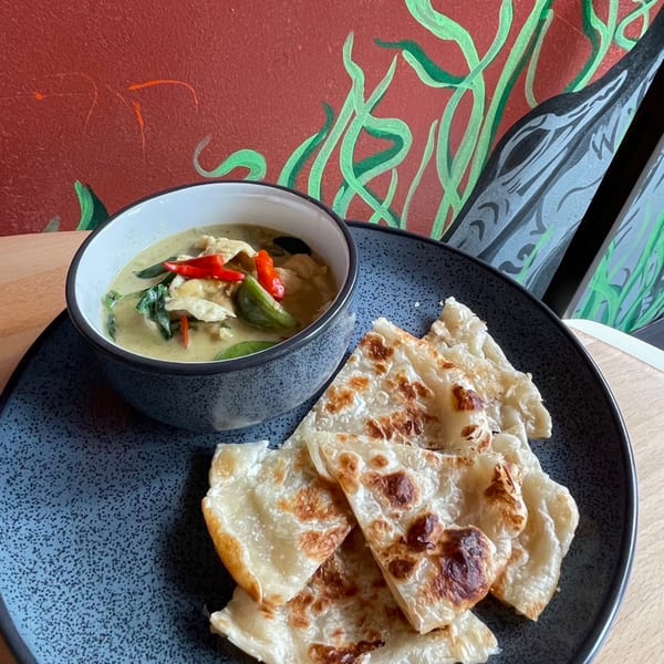 Sala Thai green curry with chicken, red chilies, and basil, served with crispy roti bread.
