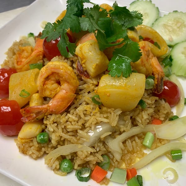 Sala Thai's seafood fried rice with shrimp, scallops, tomatoes, and cilantro, served with cucumber slices.
