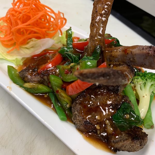 Sala Thai's lamb chops with vegetables and sauce, garnished with shredded carrots.