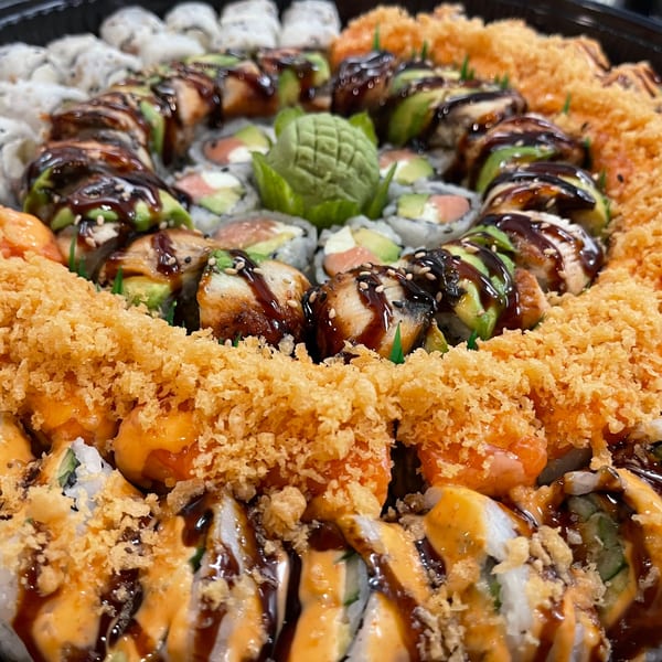 A large platter of Sala Thai sushi rolls, including dragon rolls and crispy fried rolls.