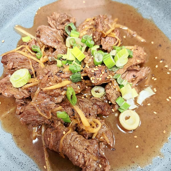 Sala Thai's beef dish with brown sauce, topped with green onions, sesame seeds, and ginger.