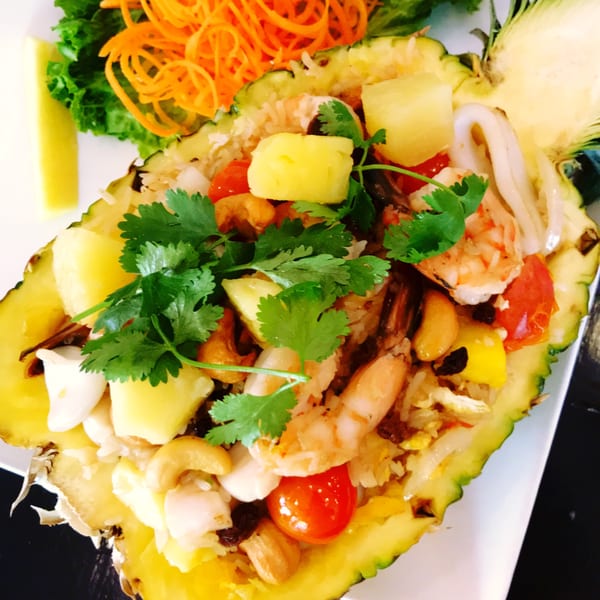 Sala Thai's pineapple fried rice with shrimp, squid, cashews, and cherry tomatoes, served in a pineapple.