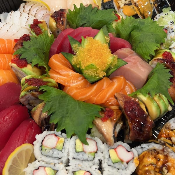 A vibrant platter of Sala Thai sushi and sashimi, featuring various rolls, fish, and garnishes.