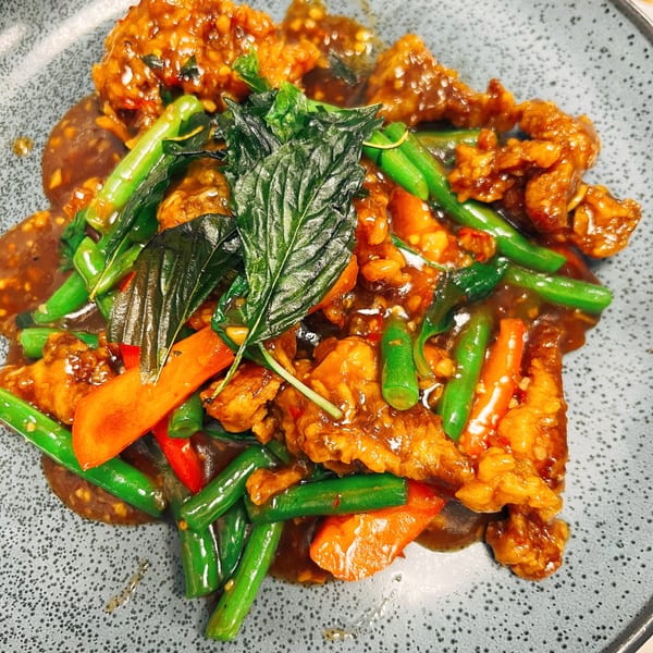 Sala Thai's crispy chicken with green beans, red peppers, and basil in a rich sauce.